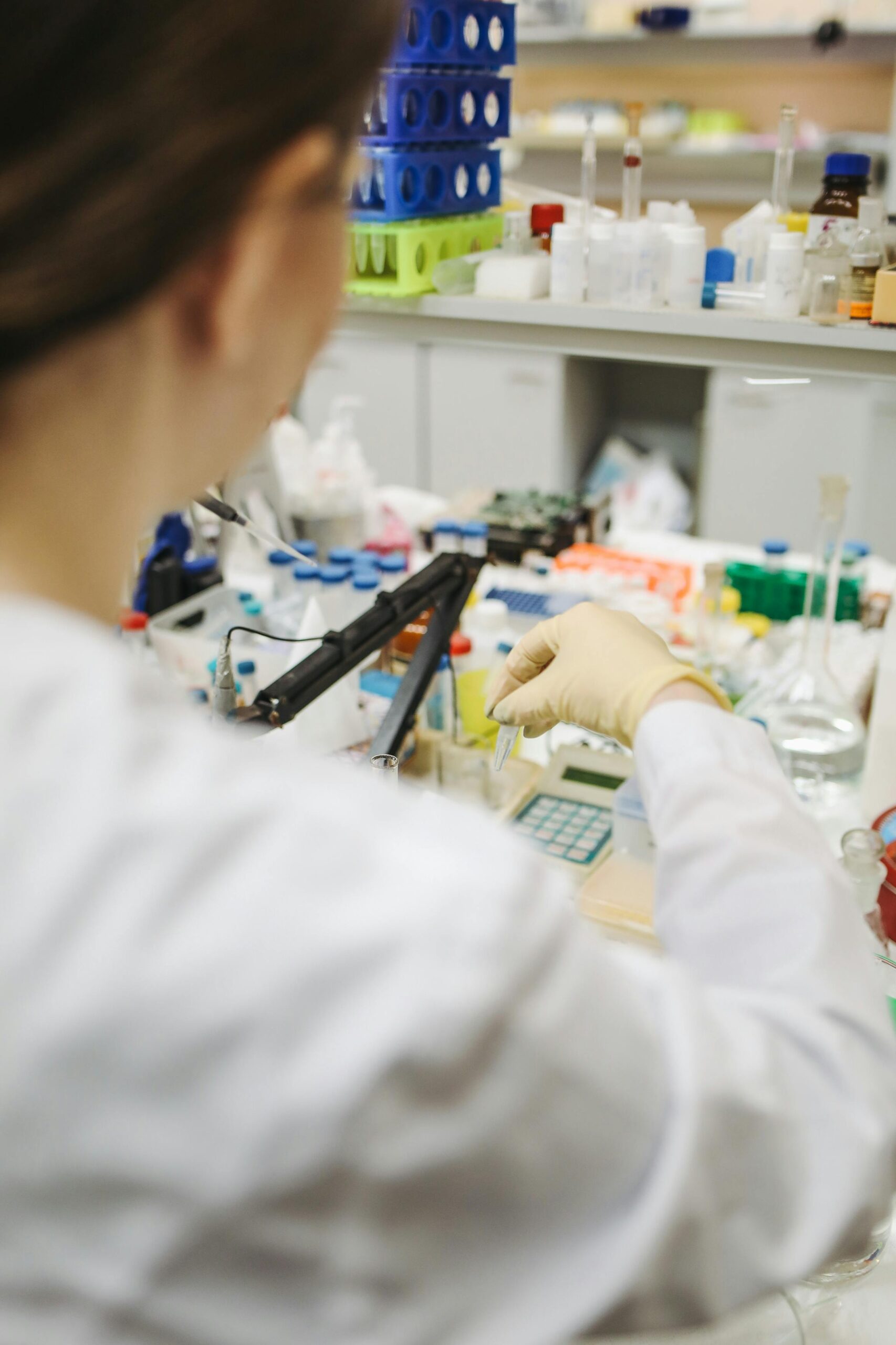 Scientist in a laboratory setting working with test tubes and samples.