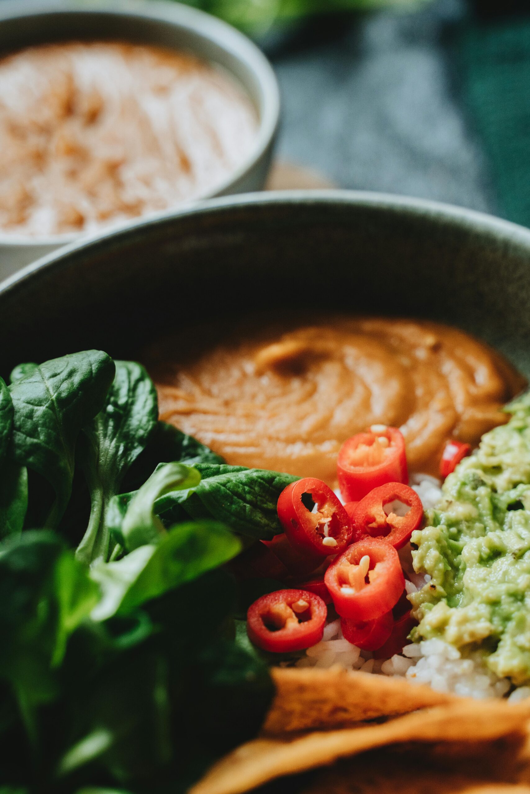 Delicious vegan Buddha bowl featuring rice, guacamole, and chili peppers for a healthy meal.
